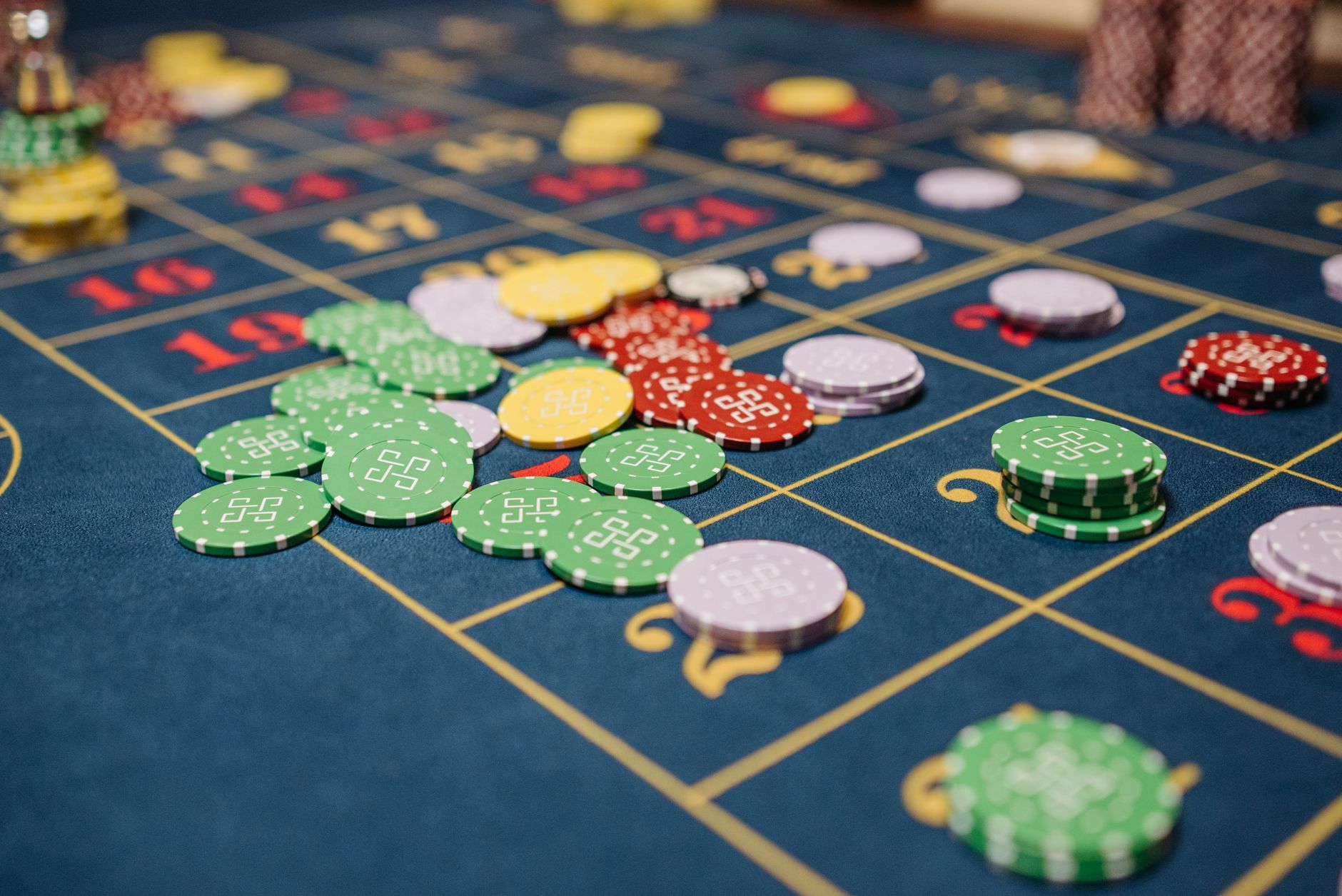 Closeup of colorful casino chips scattered on a roulette table. — The Rise of Live Dealer Games in Online Casinos