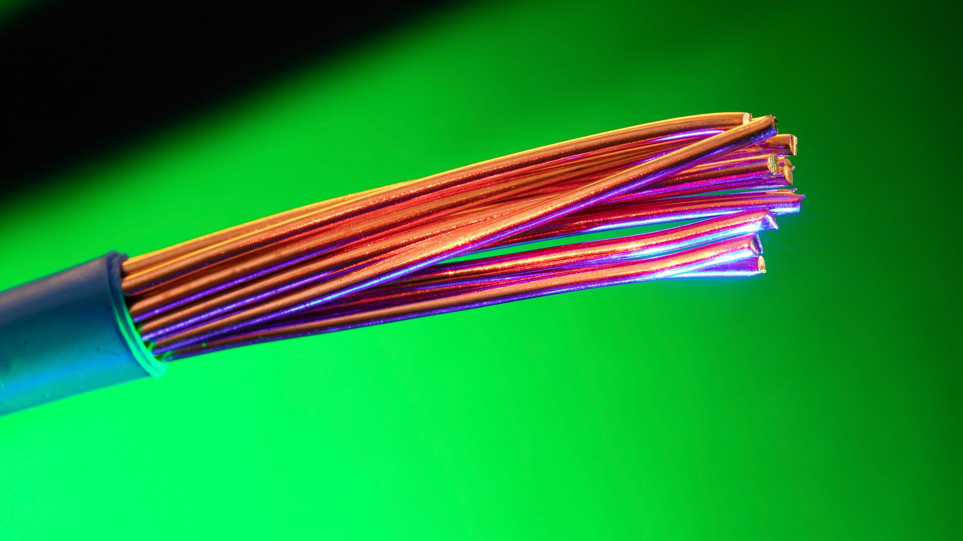 Close-up of copper wires against a green background